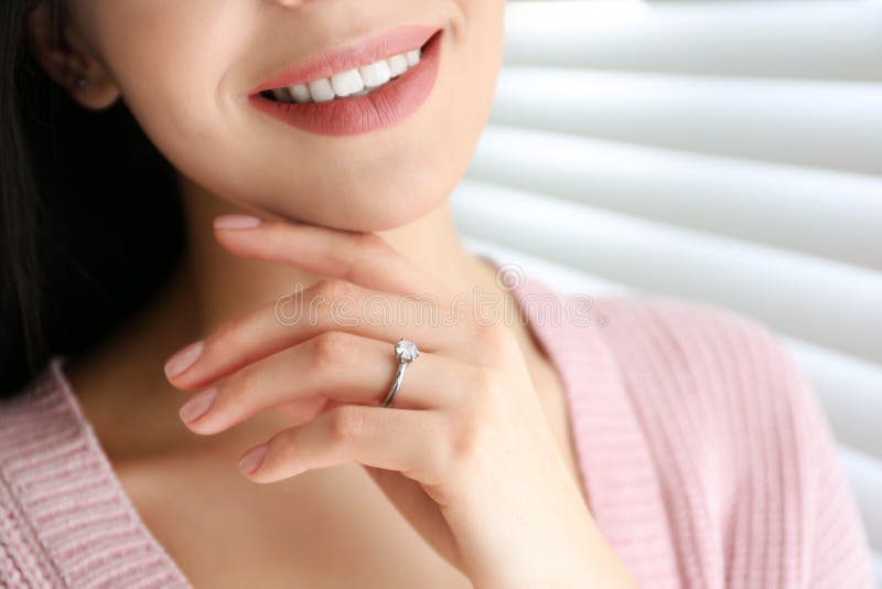 Young woman wearing beautiful engagement ring, closeup. Young woman wearing beautiful engagement ring, closeup