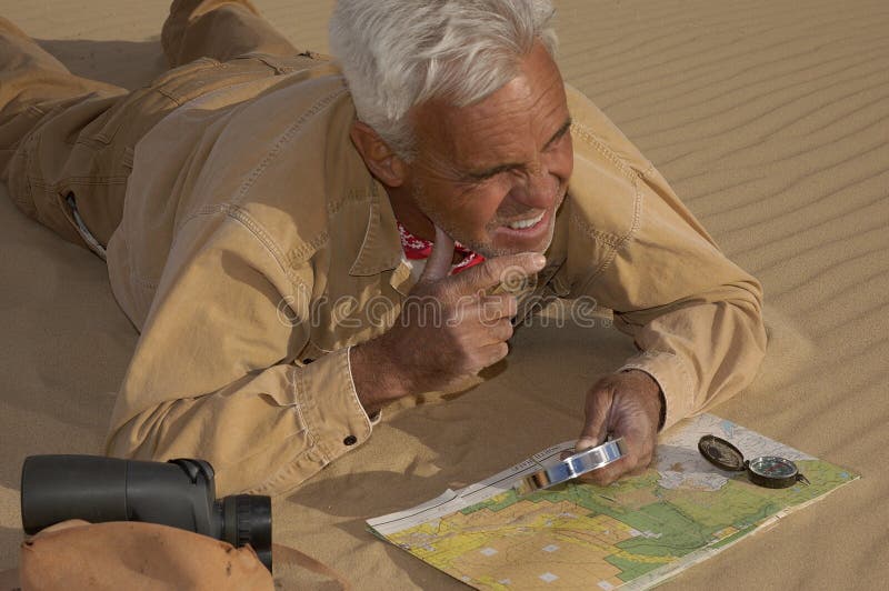 Senior adventurer man finding his way through the sand. Senior adventurer man finding his way through the sand.