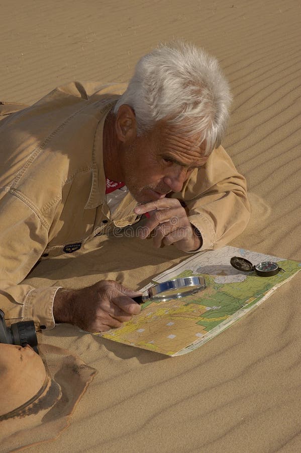 Adventurous senior man lost in the desert thinking out his plan. Adventurous senior man lost in the desert thinking out his plan.