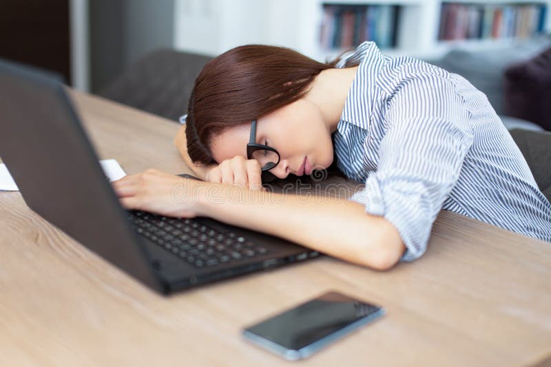 Vermoeide donkerbruine vrouwenslaap voor laptop binnen stock fotografie Vermoeide donkerbruine vrouwenslaap voor laptop binnen stock fotografie