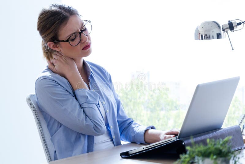 Vermoeide jonge vrouw met halspijn die haar laptop thuis met behulp van stock fotografie Vermoeide jonge vrouw met halspijn die haar laptop thuis met behulp van stock fotografie
