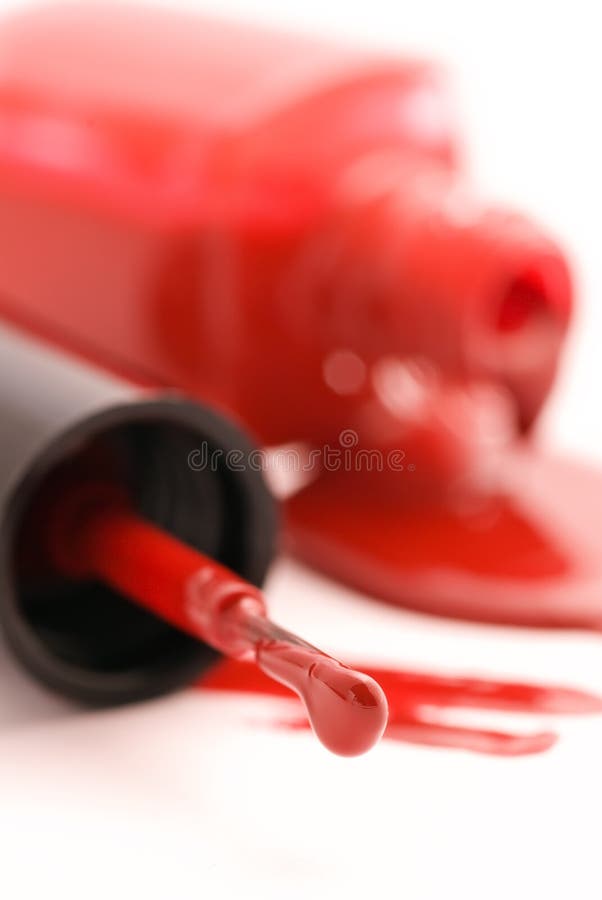 Red nail polish in open flagon and drop beside. Red nail polish in open flagon and drop beside