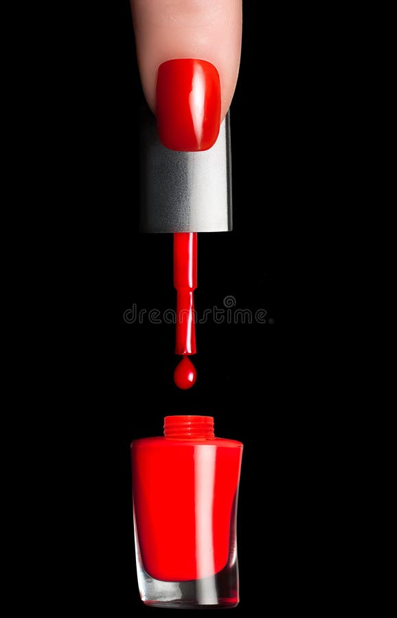 Closeup of a finger picking brush with red nail polish dripping. Manicure and nail art concept. Closeup of a finger picking brush with red nail polish dripping. Manicure and nail art concept.