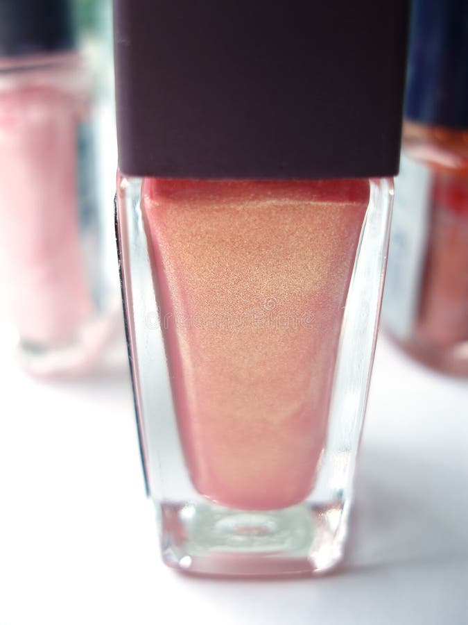 Bottle of red nail polish on white table together with other colors. Bottle of red nail polish on white table together with other colors