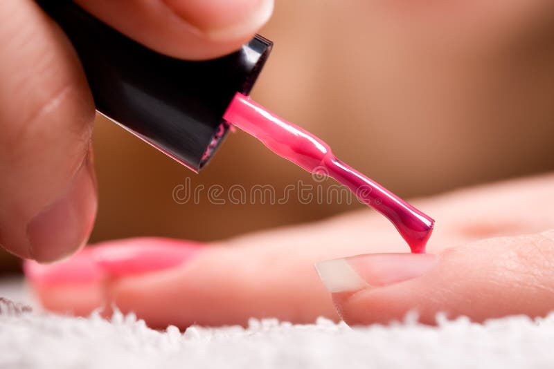 Woman applying red nail polish. Woman applying red nail polish