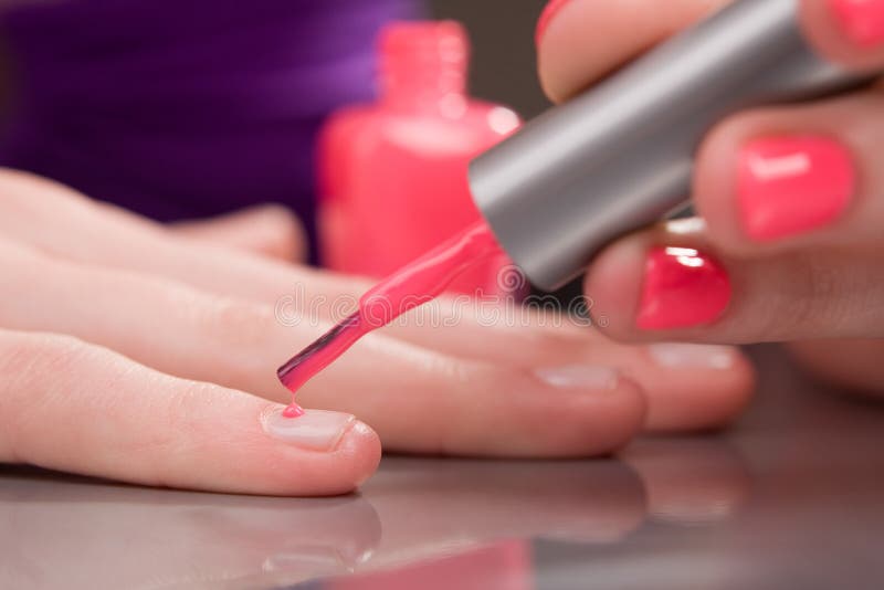 Woman applying red nail polish. Woman applying red nail polish