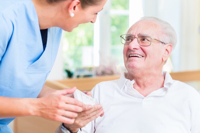 Nurse giving senior men prescription drugs. Nurse giving senior men prescription drugs