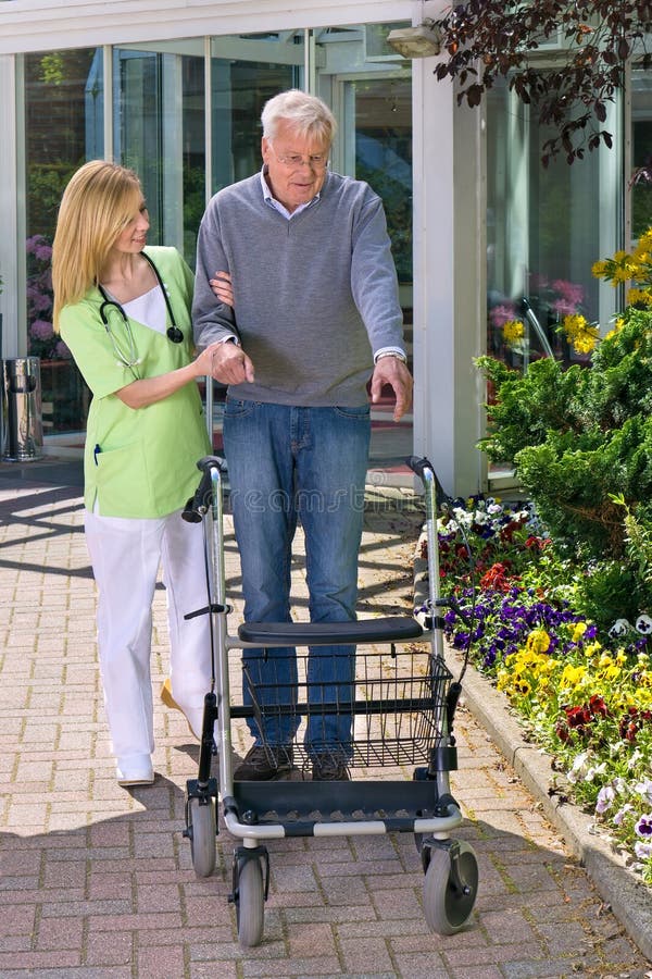 Verpleegster Helping Senior Man met Walker Outdoors stock fotografie Verpleegster Helping Senior Man met Walker Outdoors stock fotografie