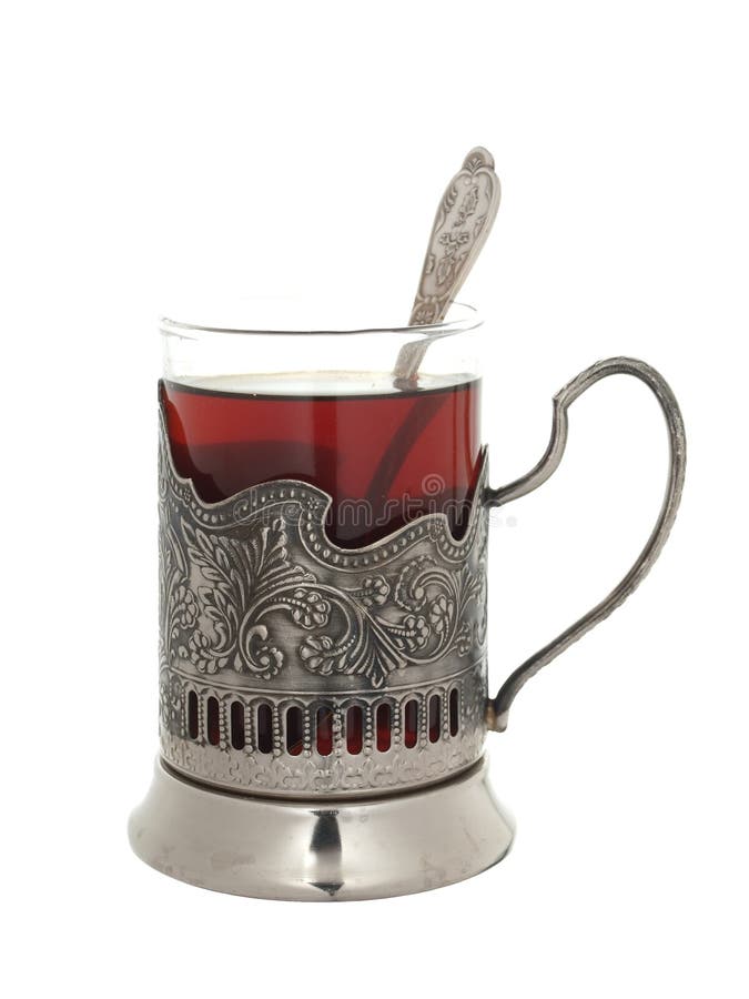 Verre avec le thé et une cuillère à café dans un support de tasse d'isolement sur un petit morceau image libre de droits Verre avec le thé et une cuillère à café dans un support de tasse d'isolement sur un petit morceau image libre de droits
