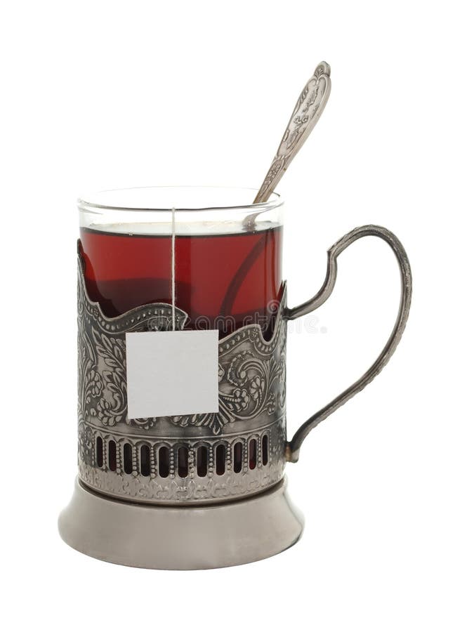 Verre avec le thé et une cuillère à café dans un support de tasse d'isolement sur un petit morceau photo stock Verre avec le thé et une cuillère à café dans un support de tasse d'isolement sur un petit morceau photo stock
