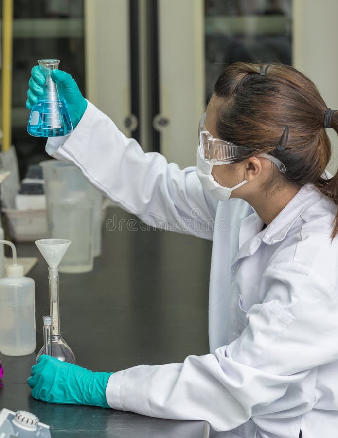Verre de expérimentation d'essai de produits chimiques de scientifique féminin photographie stock libre de droits Verre de expérimentation d'essai de produits chimiques de scientifique féminin photographie stock libre de droits
