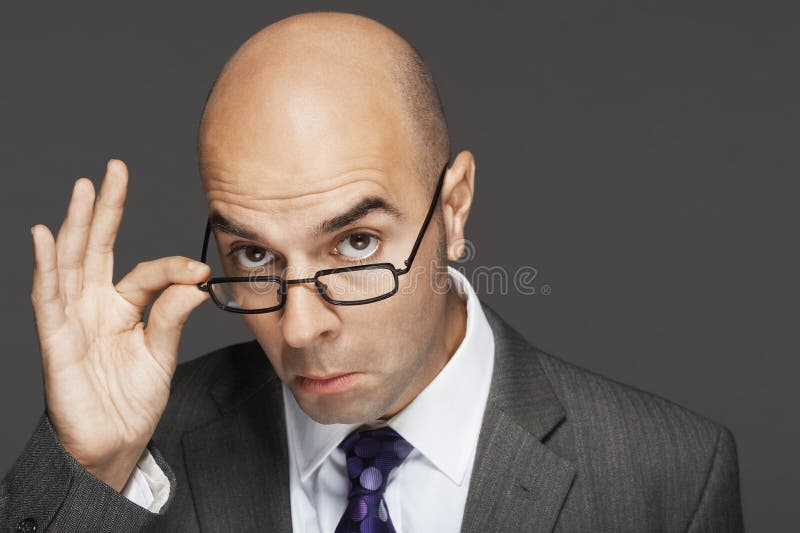 Verres chauves de With Hand On d'homme d'affaires faisant un visage images stock Verres chauves de With Hand On d'homme d'affaires faisant un visage images stock