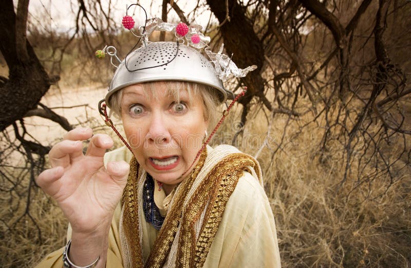 Crazy woman wearing a metal colander for a helmet. Crazy woman wearing a metal colander for a helmet