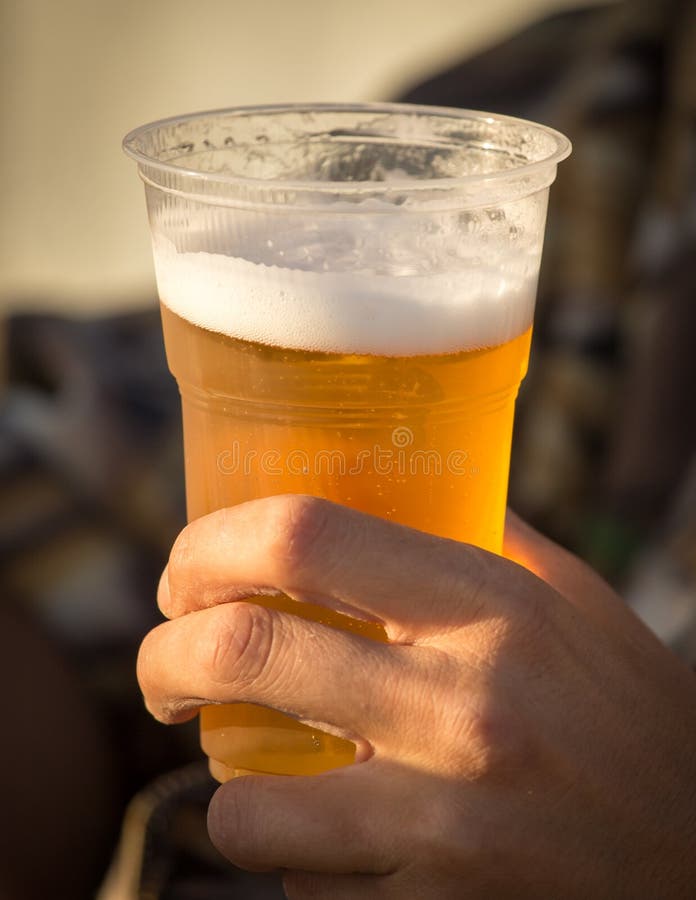 Vers bier in een plastic kop in de hand royalty-vrije stock afbeelding Vers bier in een plastic kop in de hand royalty-vrije stock afbeelding