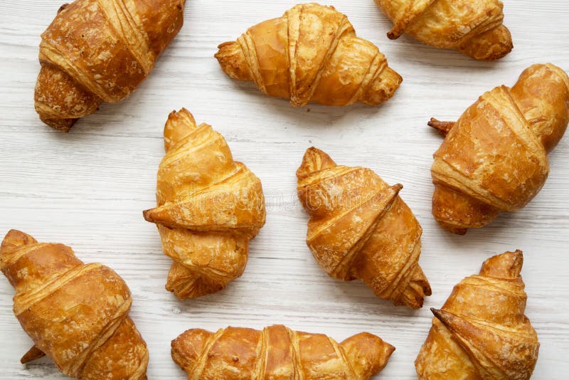Vers gebakken gouden croissants op witte houten, hoogste mening Van hierboven stock afbeeldingen Vers gebakken gouden croissants op witte houten, hoogste mening Van hierboven stock afbeeldingen