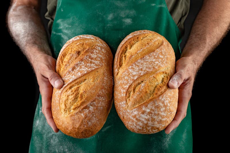 Vers gebakken smakelijk brood in baker& x27; s handen Smakelijke gebakken goederen rechtstreeks van de bakkerij stock fotografie Vers gebakken smakelijk brood in baker& x27; s handen Smakelijke gebakken goederen rechtstreeks van de bakkerij stock fotografie
