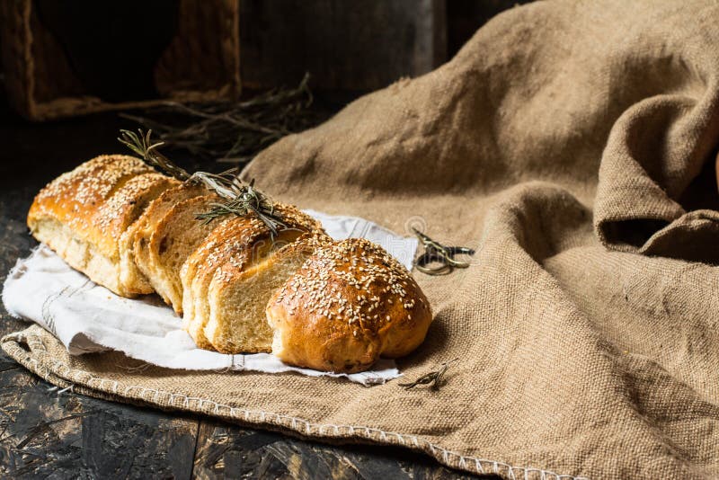 Vers gebakken tarwebrood op natuurlijke linnenservet en zak Eigengemaakte bakkerij Stilleven van brood Plak van gouden rustieke k royalty-vrije stock fotografie Vers gebakken tarwebrood op natuurlijke linnenservet en zak Eigengemaakte bakkerij Stilleven van brood Plak van gouden rustieke k royalty-vrije stock fotografie