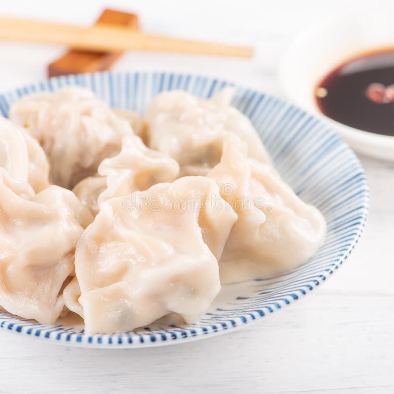 Vers, heerlijk gekookt varkensvlees, garnaal gyoza-dumplings op witte achtergrond met sojasaus en stokjes, dicht bij elkaar, leve stock foto Vers, heerlijk gekookt varkensvlees, garnaal gyoza-dumplings op witte achtergrond met sojasaus en stokjes, dicht bij elkaar, leve stock foto