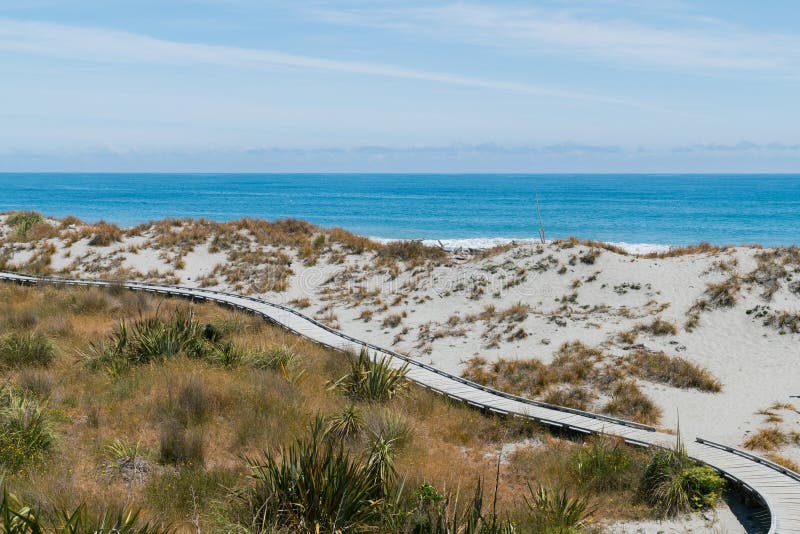 Versanden Sie Strand mit hölzerner Wegweise über Ozeanskylinen stockfoto Versanden Sie Strand mit hölzerner Wegweise über Ozeanskylinen stockfoto