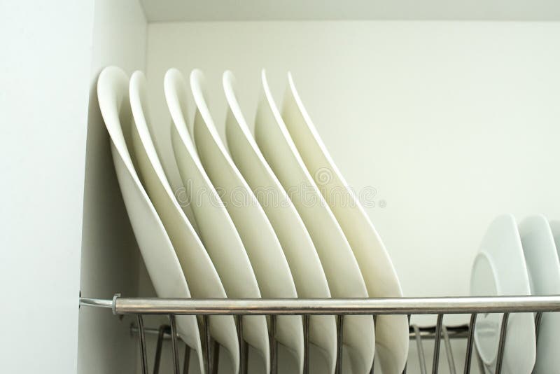 Verscheidene witte platen in de kast bevinden zich verticaal in de droger stock afbeeldingen Verscheidene witte platen in de kast bevinden zich verticaal in de droger stock afbeeldingen