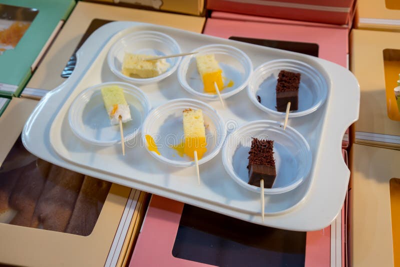 Verscheidenheid van cakesteekproeven in kleine plastic proevende kop op wit RT royalty-vrije stock fotografie Verscheidenheid van cakesteekproeven in kleine plastic proevende kop op wit RT royalty-vrije stock fotografie