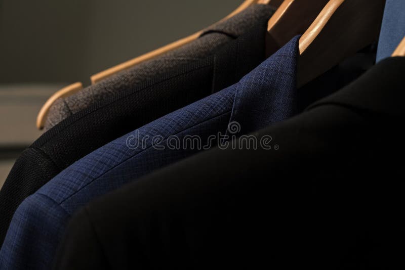 Verschiedene Klagen Jacken auf Aufhängern im Shop auf unscharfem Hintergrund stockbild Verschiedene Klagen Jacken auf Aufhängern im Shop auf unscharfem Hintergrund stockbild