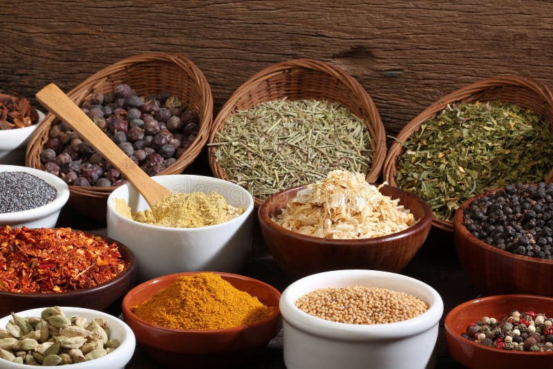 Different bowls of spices over a wooden background. Different bowls of spices over a wooden background