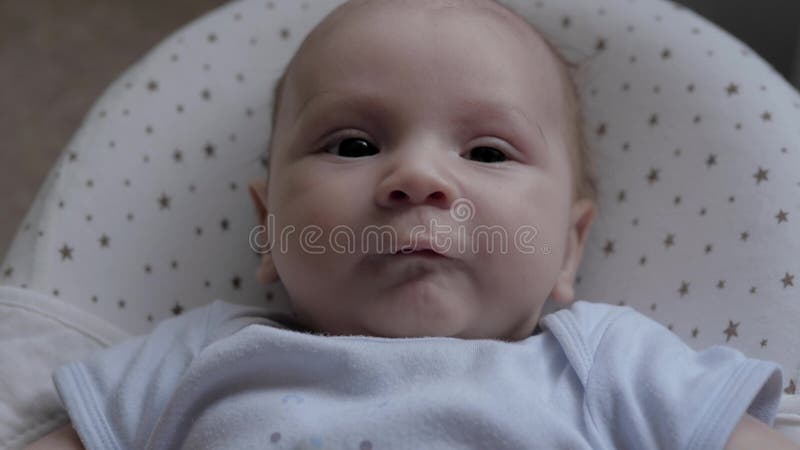 Verschillende gezichtsuitdrukkingen van pasgeboren kinderen kijken naar camera en pulls handvatten