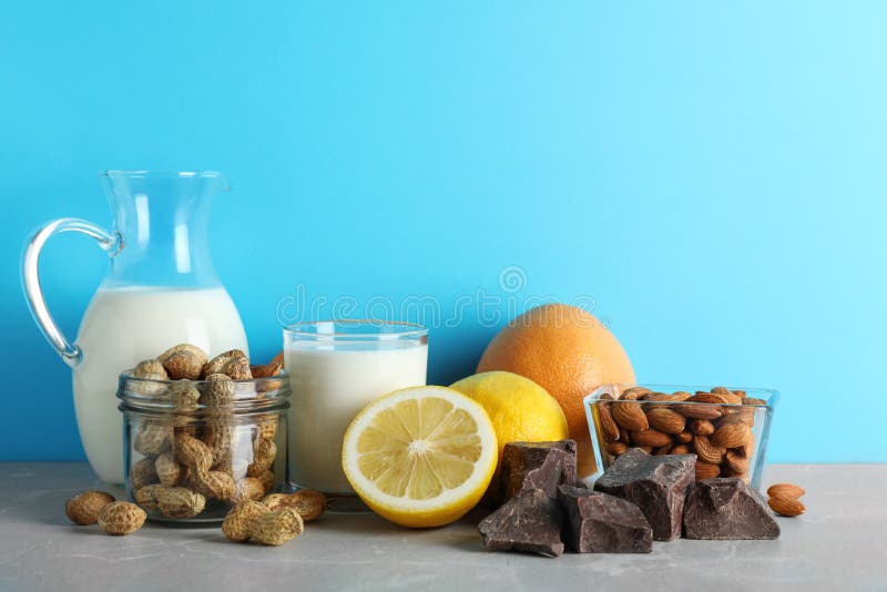 Verschillende producten op stenen tafel tegen lichtblauwe achtergrond Voedselallergie