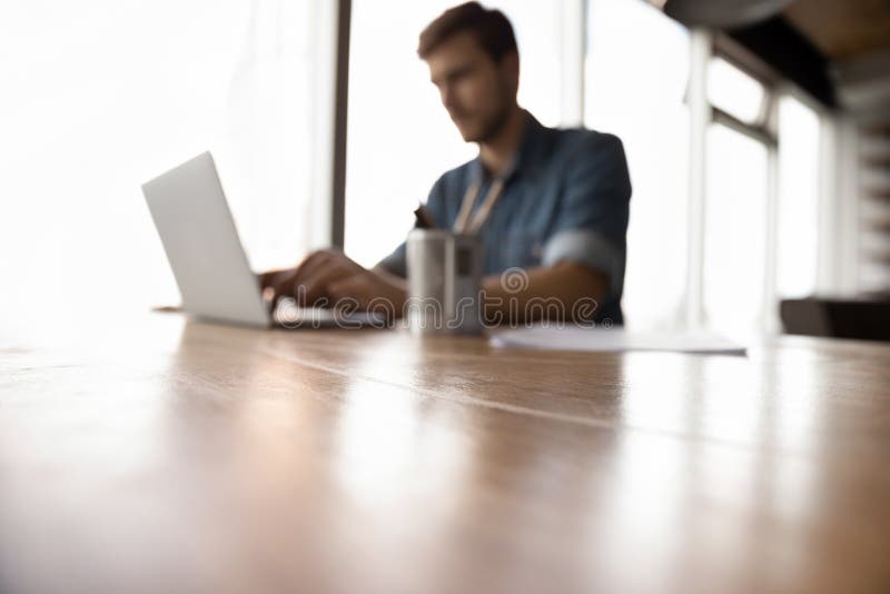 Verschwommene Sicht auf männliche Mitarbeiter, die am Laptop arbeiten stockfotos
