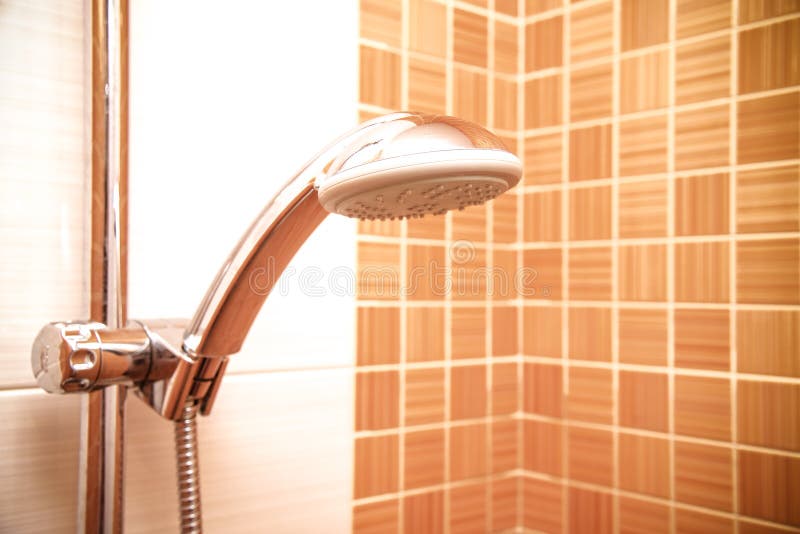 Verse douche waar Water die van douchehoofd en tapkraan lopen in moderne badkamers met oranje muur royalty-vrije stock afbeeldingen Verse douche waar Water die van douchehoofd en tapkraan lopen in moderne badkamers met oranje muur royalty-vrije stock afbeeldingen