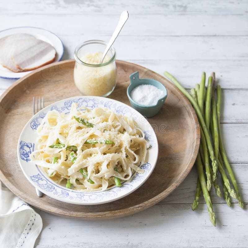 Verse eigengemaakte deegwaren met asperge, kaas en roomsaus op houten dienblad stock foto's Verse eigengemaakte deegwaren met asperge, kaas en roomsaus op houten dienblad stock foto's