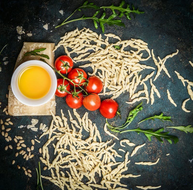 Verse eigengemaakte Italiaanse deegwaren met ingrediënten voor het smakelijke koken: parmezaanse kaas, olie, tomaten en arugula o royalty-vrije stock fotografie Verse eigengemaakte Italiaanse deegwaren met ingrediënten voor het smakelijke koken: parmezaanse kaas, olie, tomaten en arugula o royalty-vrije stock fotografie