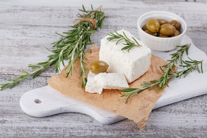 Verse feta-kaas met rozemarijn op witte houten dienende raad royalty-vrije stock afbeelding Verse feta-kaas met rozemarijn op witte houten dienende raad royalty-vrije stock afbeelding