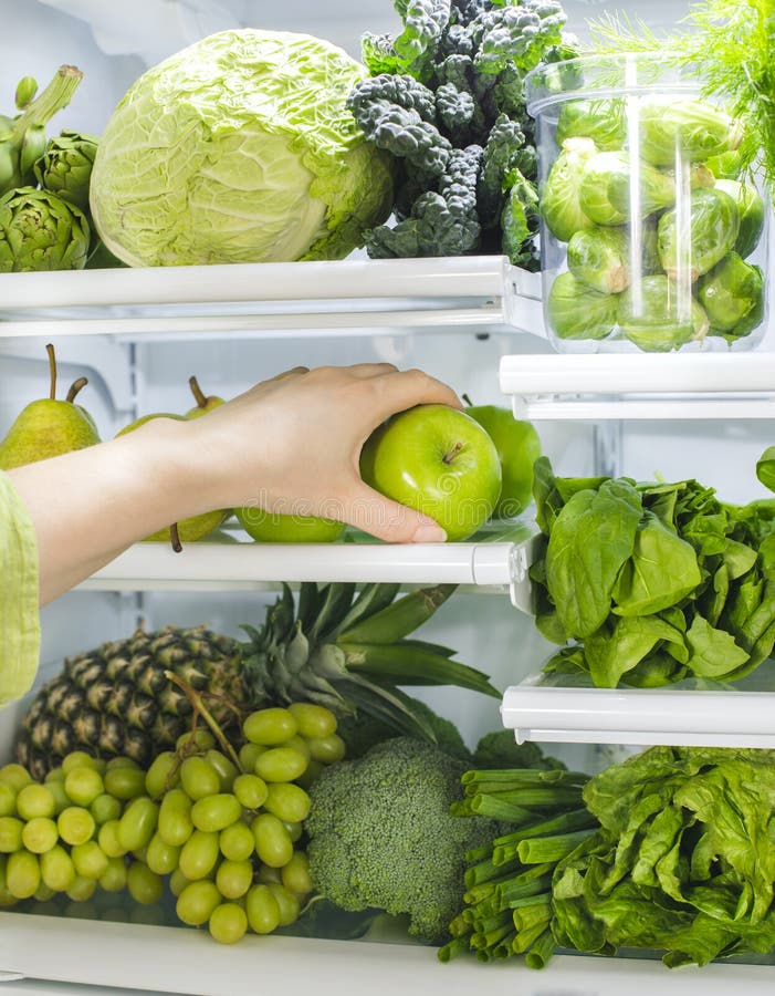 Verse groene groenten en vruchten in koelkast De vrouw neemt de groene appel van de open ijskast royalty-vrije stock foto's Verse groene groenten en vruchten in koelkast De vrouw neemt de groene appel van de open ijskast royalty-vrije stock foto's