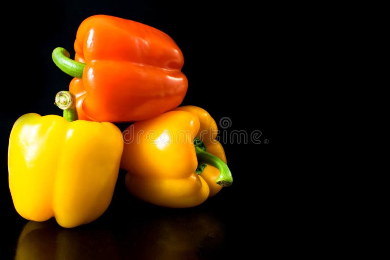 Verse groenten Drie gele sinaasappel, groene paprika's op een zwarte achtergrond stock fotografie Verse groenten Drie gele sinaasappel, groene paprika's op een zwarte achtergrond stock fotografie