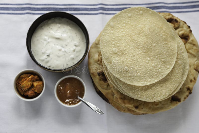 Verse Indische vlakke broden Naans en poppadums stock foto Verse Indische vlakke broden Naans en poppadums stock foto