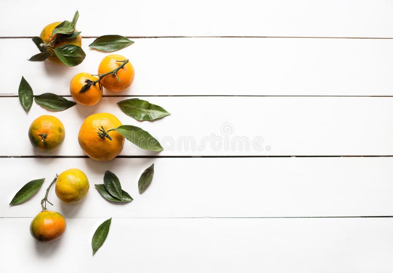 Verse oranje mandarijnen met bladeren op de witte houten mening van de lijstbovenkant stock foto Verse oranje mandarijnen met bladeren op de witte houten mening van de lijstbovenkant stock foto