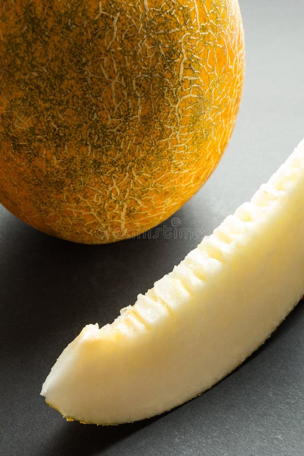 Verse organische die kantaloepmeloenen op zwarte verticale achtergrond worden gesneden, stock foto Verse organische die kantaloepmeloenen op zwarte verticale achtergrond worden gesneden, stock foto