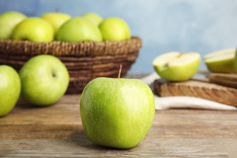 Verse rijpe groene appel op houten lijst tegen blauwe achtergrond royalty-vrije stock fotografie Verse rijpe groene appel op houten lijst tegen blauwe achtergrond royalty-vrije stock fotografie