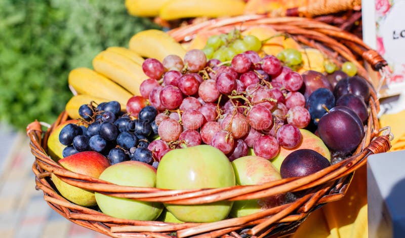 Verse vruchten in een mand Appelen, pruimen, druiven en bananen op de lijst van het cateringsbanket royalty-vrije stock foto Verse vruchten in een mand Appelen, pruimen, druiven en bananen op de lijst van het cateringsbanket royalty-vrije stock foto