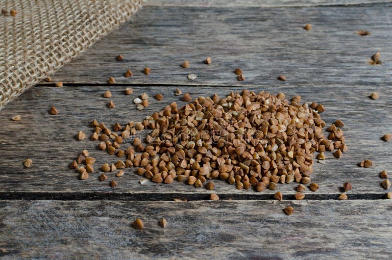 Verspreid boekweit op houten lijst stock foto Verspreid boekweit op houten lijst stock foto