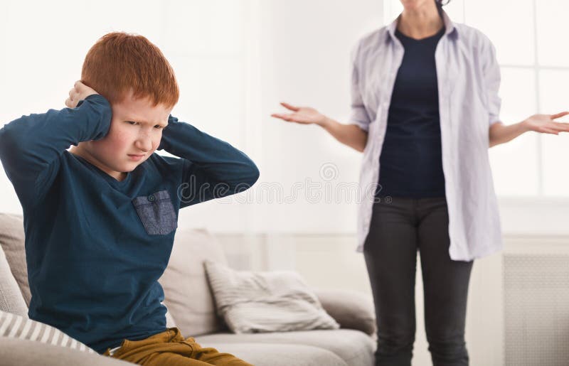 Verstoorde jongens dicht oren wanneer moeder die hem berispen royalty-vrije stock fotografie Verstoorde jongens dicht oren wanneer moeder die hem berispen royalty-vrije stock fotografie