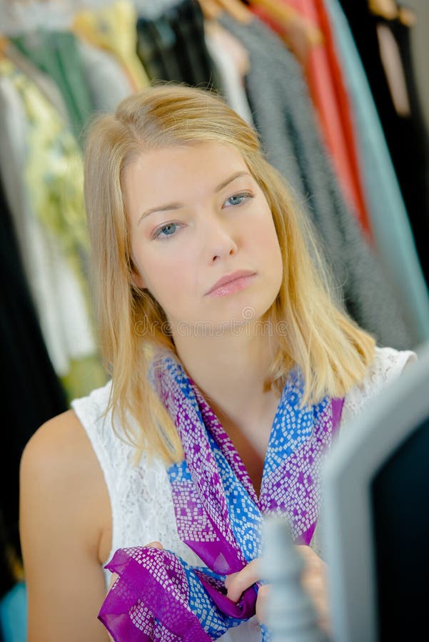 Trying on a scarf in a shop. Trying on a scarf in a shop