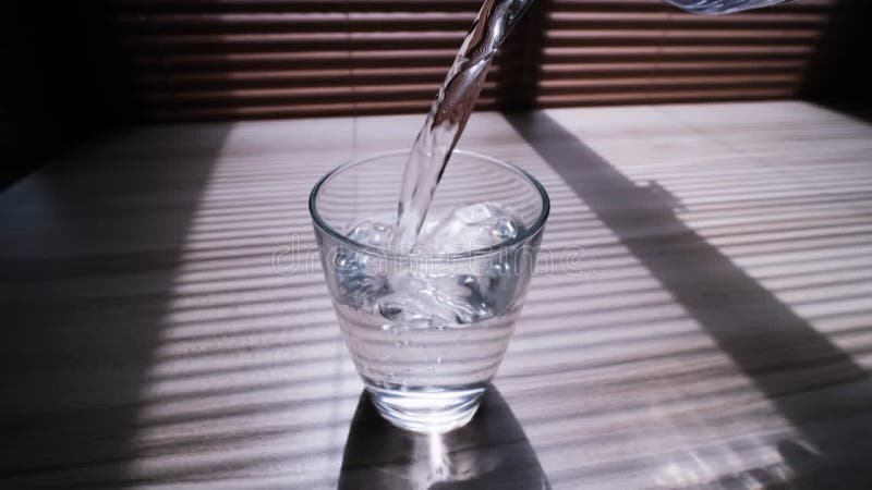 Verter agua de una botella de plástico en un vaso