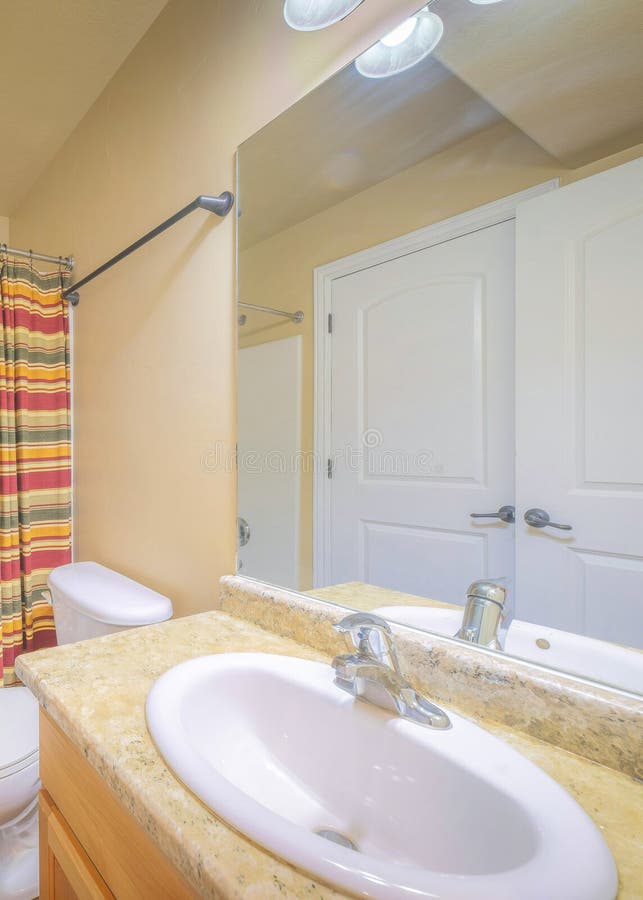 Vertical Bathroom Interior with Two White Doors and Warm Color Walls