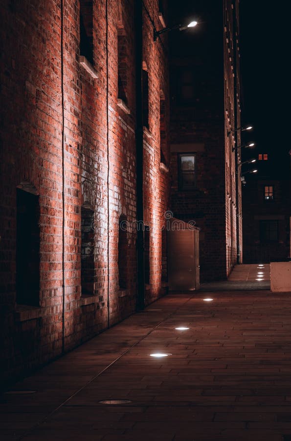 Vertical of a brick building illuminated by street lights royalty free stock photos