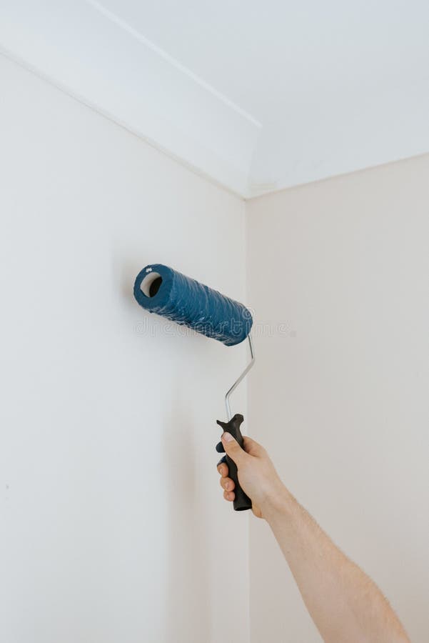 Vertical closeup shot of a person using paint rollers with the color blue royalty free stock photo Vertical closeup shot of a person using paint rollers with the color blue royalty free stock photo
