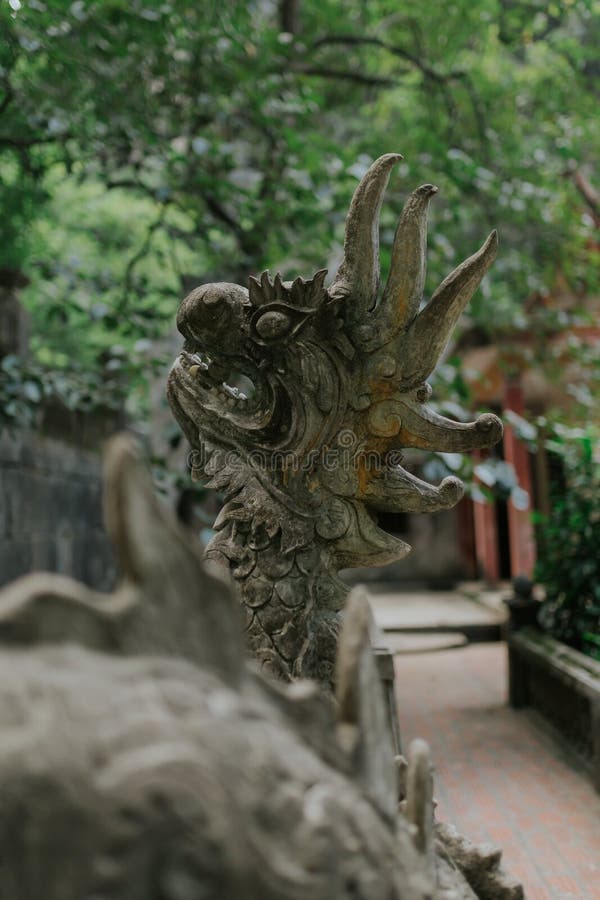 Vertical closeup shot of a statue of a dragon in the park during daytime royalty free stock image