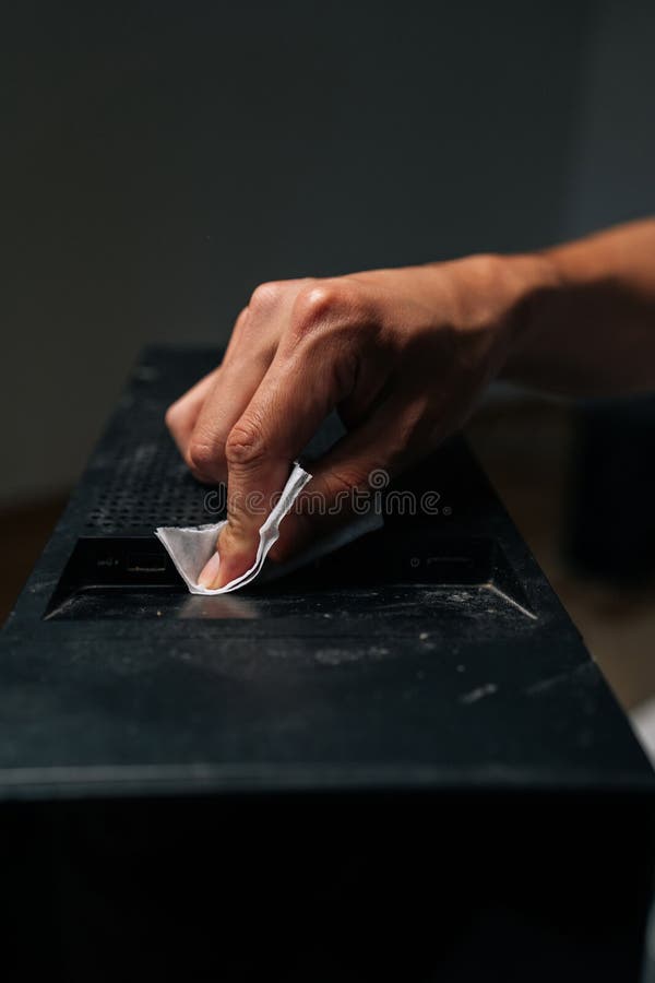 Vertical cropped shot of technician hand cleaning dust and grime from computer case with tissue, ensuring optimal royalty free stock photography